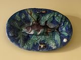 une assiette bleue et verte sur laquelle est représenté un poisson