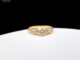 une bague en or sertie de trois diamants, posée sur une assiette blanche