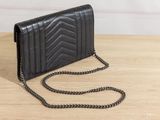 a black leather wallet with a chain on a wooden table