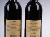 two bottles of red wine sitting next to each other on a table