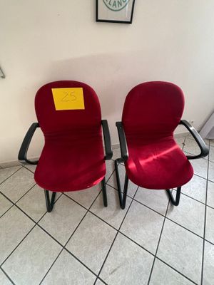 deux chaises rouges placées l'une à côté de l'autre sur un sol carrelé