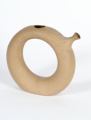 un petit vase posé sur une surface blanche