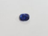 a blue sapphire stone on a white surface