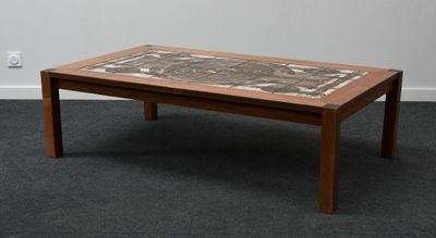 une table basse avec un plateau en carrelage, posée sur un sol recouvert de moquette