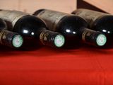 several bottles of wine are lined up on a red cloth