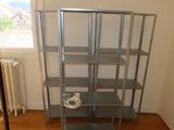 a metal shelving with wires on it in the corner of a room