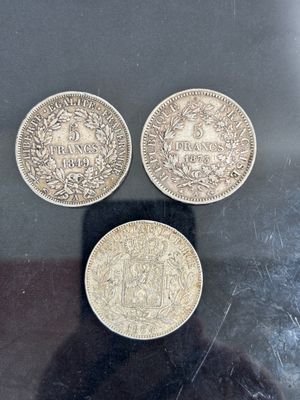 trois pièces d'argent posées sur une surface noire