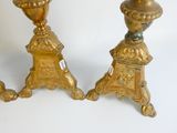 pair of antique brass candlesticks with ornate designs on each side