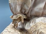 a close up of a doll ' s hands on a chair