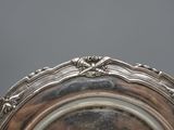an antique silver plate with a decorative design on the rim