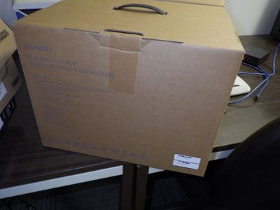 une boîte en carton posée sur un bureau d'ordinateur