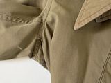 the back view of a man ' s khaki jacket with a buttoned collar