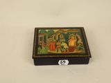 an old wooden box with a painting on it sitting on a table