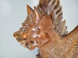 a wooden statue of a dragon with a long tail