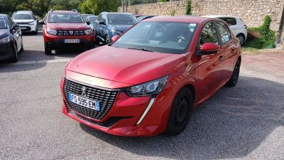 une voiture rouge garée dans un parking à côté d'autres voitures
