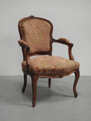 une chaise à l'ancienne dont l'assise est recouverte d'un tissu à motifs floraux