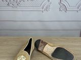 beige and black slippers on a wooden table in front of a wall