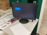a computer monitor sitting on a desk in an office