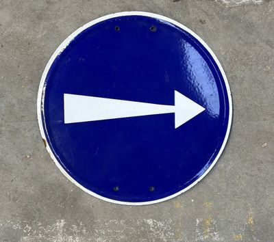 un panneau bleu sur lequel figure une flèche blanche