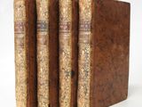 three old books sitting on top of each other on a white surface