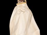 an image of a doll is dressed in a white cloak and hat