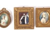 three framed portraits of men and women on a white wall
