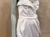 a mannequin wearing a white dress on a mannequin stand