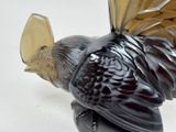 a glass sculpture of a bird on a stand