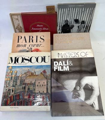 trois livres sont posés sur une table recouverte d'une nappe blanche