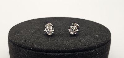 un gros plan sur une paire de boucles d'oreilles posées sur une boîte noire