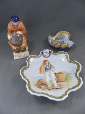 une assiette ornée d'une figurine représentant un homme et un bol sur lequel est représenté un oiseau
