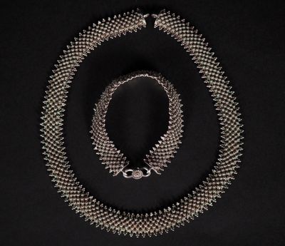 un collier et un bracelet en argent sur fond noir