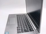 a silver laptop computer sitting on top of a white table