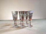 quatre verres à vin posés sur une table, sur fond blanc