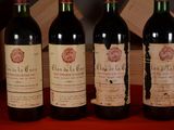 three bottles of red wine are lined up on a table