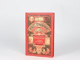an old book with a red cover sitting on top of a white surface