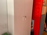 a white cabinet and a red wall in a room