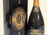 une bouteille de champagne dans un coffret noir, à côté d'un autre coffret noir