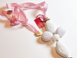 un collier blanc auquel est attaché un ruban rose