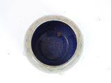 a blue bowl sitting on a table with a white background