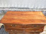 une petite commode en bois posée par terre