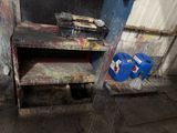a dirty kitchen with a stove and a trash can