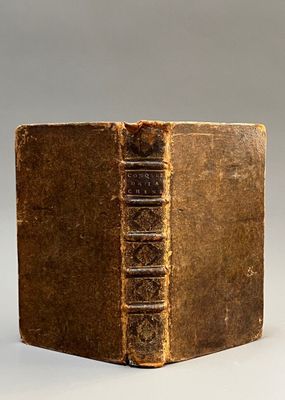 an old book sitting on top of a table next to a white wall