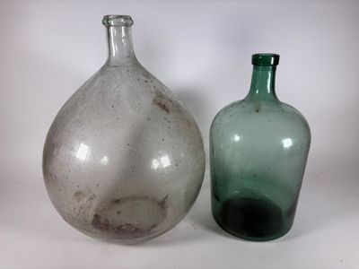 deux bouteilles en verre posées l'une à côté de l'autre sur une surface blanche