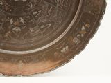 a brown plate with designs on it sitting on a table