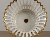 a white bowl with gold trim on a wooden table