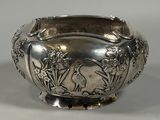 a silver bowl with a bird and flowers design on it