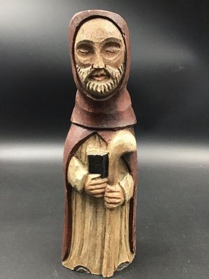 figurine en bois représentant un moine tenant un téléphone portable