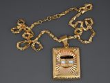 an image of a gold necklace with a picture on it