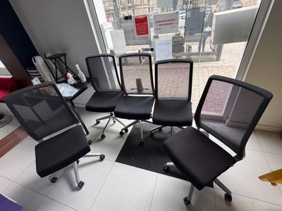 six office chairs in a room with a view of the city